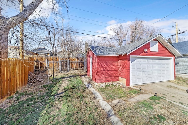 view of yard featuring an outbuilding, a detached garage, and fence