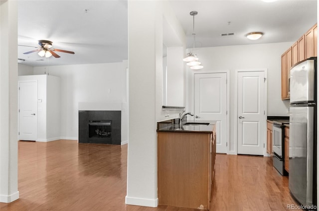 4100 Albion St Unit 614, Denver, CO 80216 - kitchen featuring range with electric stovetop, a sink, dark countertops, freestanding refrigerator, and a ceiling fan