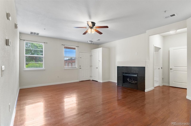 4100 Albion St Unit 614, Denver, CO 80216 - unfurnished living room featuring ceiling fan, a tile fireplace, wood finished floors, and baseboards