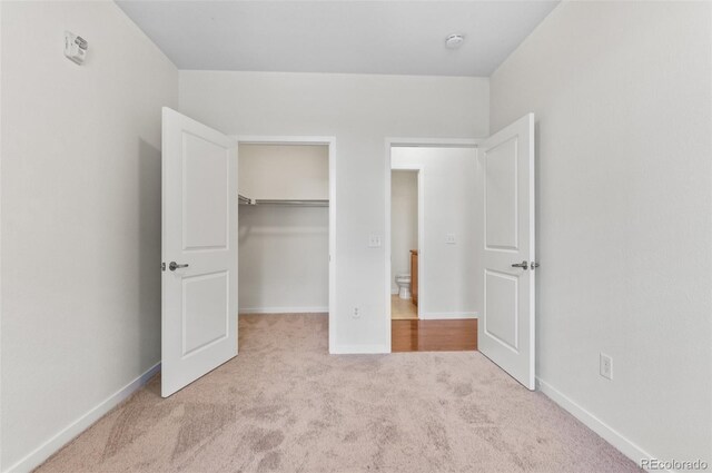 4100 Albion St Unit 614, Denver, CO 80216 - unfurnished bedroom with carpet, a walk in closet, a closet, and baseboards