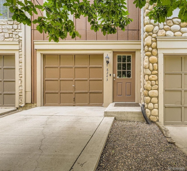 8243 S Fillmore Cir, Centennial, CO 80122 - doorway to property featuring driveway, a garage, and stone siding
