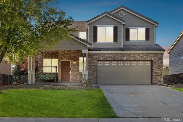 view of front of property with a front yard, brick siding, fence, and driveway