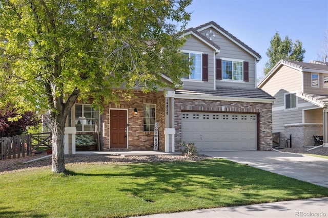 view of front facade featuring a front yard, brick siding, fence, and driveway