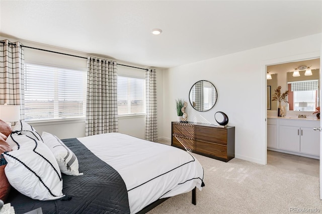 carpeted bedroom with ensuite bath and sink