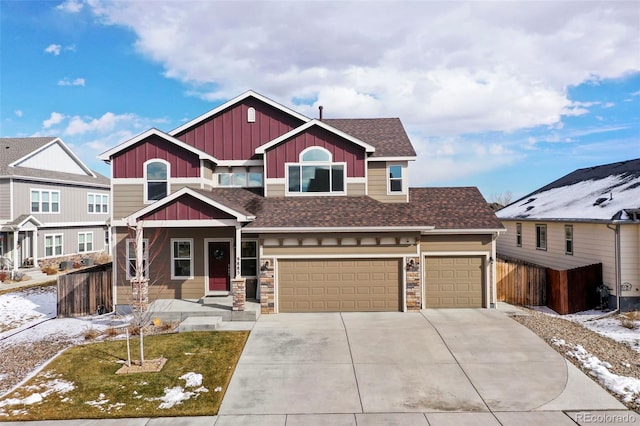 craftsman inspired home featuring driveway, a shingled roof, fence, and board and batten siding