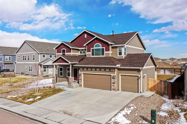 view of front facade with a shingled roof, concrete driveway, fence, and an attached garage