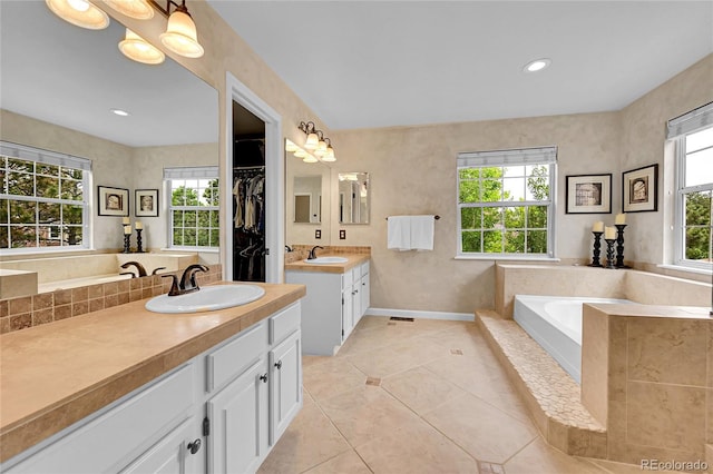 1583 Sunset Ridge Rd, Highlands Ranch, CO 80126 - full bathroom with two vanities, a garden tub, tile patterned floors, baseboards, and a walk in closet