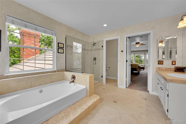 1583 Sunset Ridge Rd, Highlands Ranch, CO 80126 - ensuite bathroom featuring vanity, a stall shower, a garden tub, tile patterned flooring, and baseboards