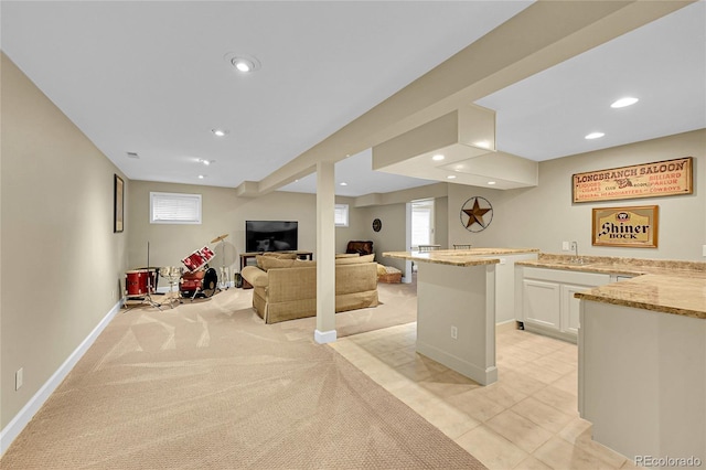 1583 Sunset Ridge Rd, Highlands Ranch, CO 80126 - kitchen featuring light stone counters, white cabinets, recessed lighting, open floor plan, and baseboards
