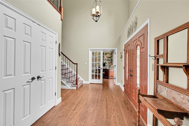 1583 Sunset Ridge Rd, Highlands Ranch, CO 80126 - entryway featuring a towering ceiling, french doors, stairs, light wood finished floors, and baseboards