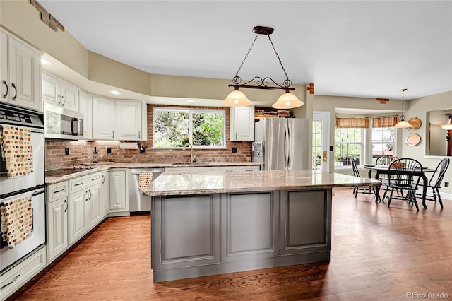1583 Sunset Ridge Rd, Highlands Ranch, CO 80126 - kitchen featuring stainless steel appliances, a center island, backsplash, and a sink
