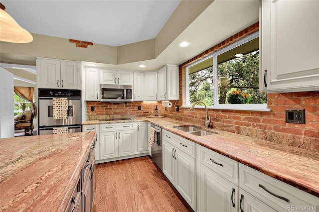 1583 Sunset Ridge Rd, Highlands Ranch, CO 80126 - kitchen with appliances with stainless steel finishes, a sink, white cabinetry, light stone countertops, and recessed lighting