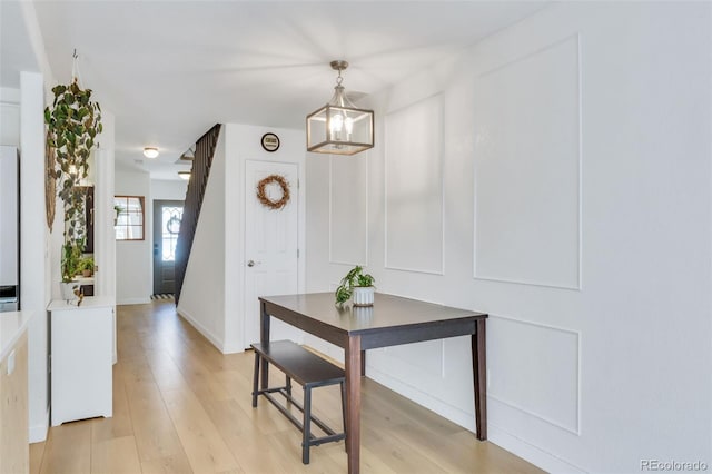 dining space with a chandelier, light wood finished floors, and baseboards
