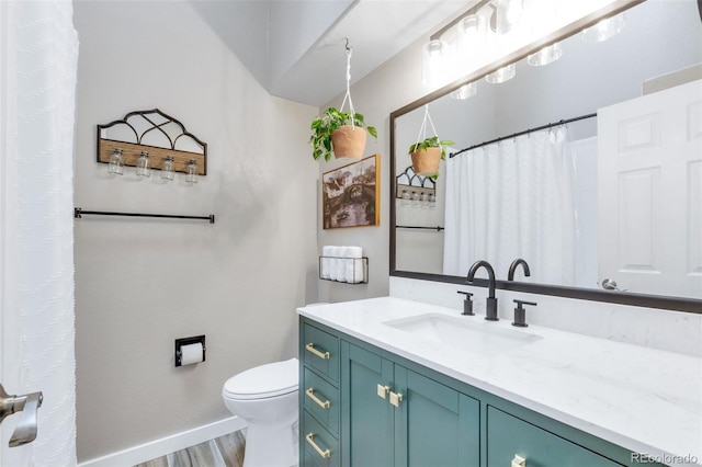bathroom with toilet, baseboards, wood finished floors, vanity, and curtained shower