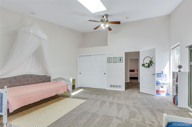 bedroom with high vaulted ceiling, carpet floors, a skylight, ceiling fan, and baseboards