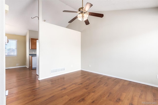 empty room with baseboards, visible vents, a ceiling fan, wood finished floors, and vaulted ceiling