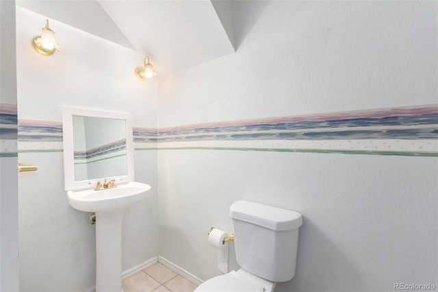 half bathroom with tile patterned flooring, lofted ceiling, and toilet