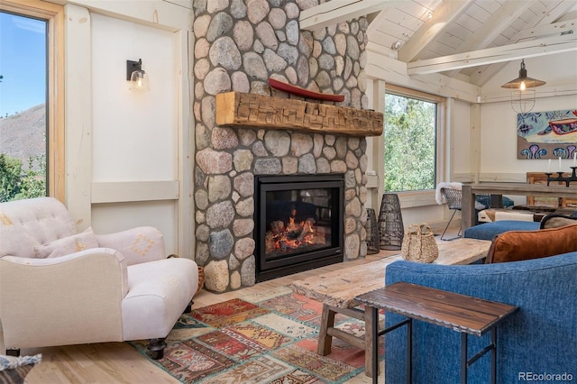 living room featuring wooden ceiling, a stone fireplace, lofted ceiling with beams, and hardwood / wood-style flooring