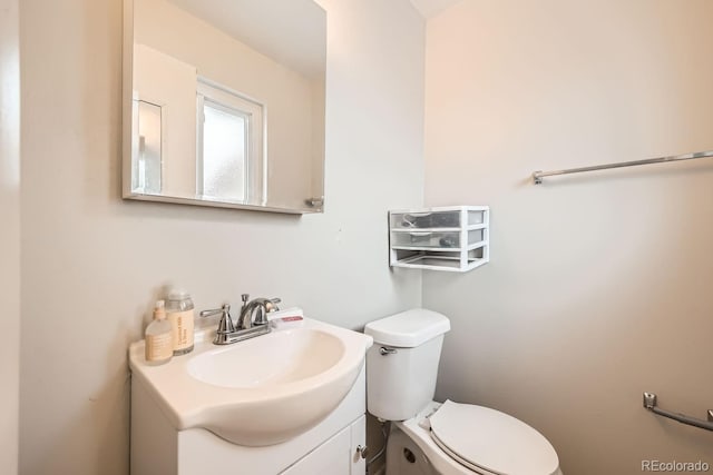 half bathroom with vanity and toilet