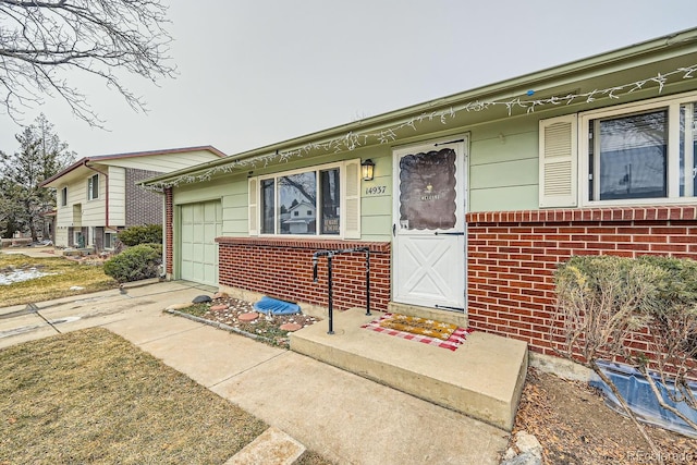 view of front facade featuring a garage, concrete driveway, and brick siding