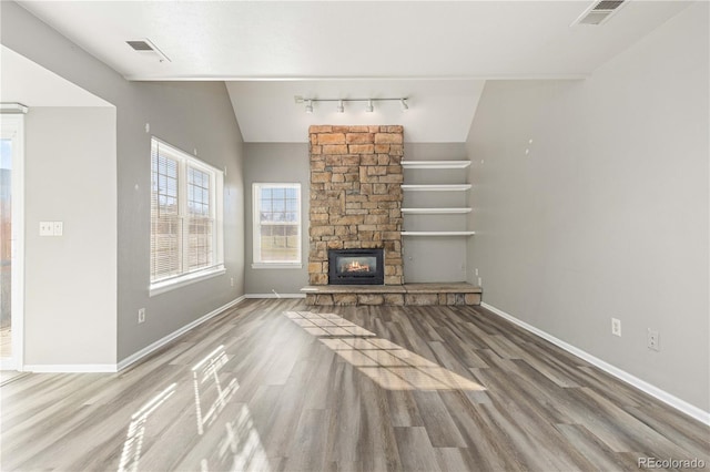 unfurnished living room with a fireplace, hardwood / wood-style floors, and lofted ceiling