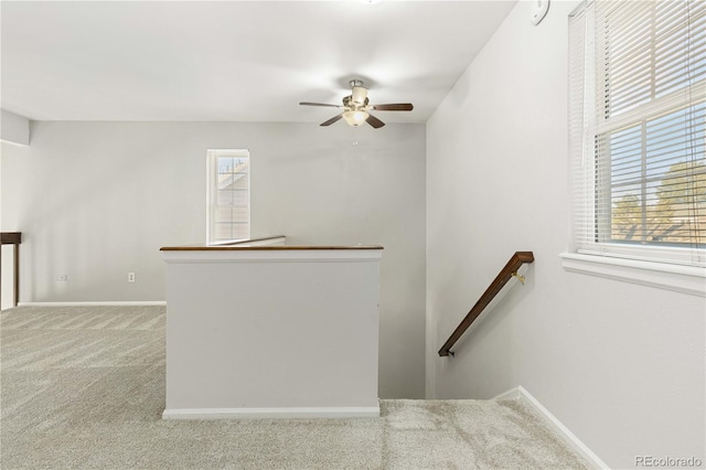 staircase with carpet flooring, ceiling fan, and a healthy amount of sunlight