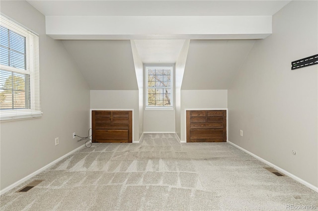 additional living space with vaulted ceiling with beams and light colored carpet