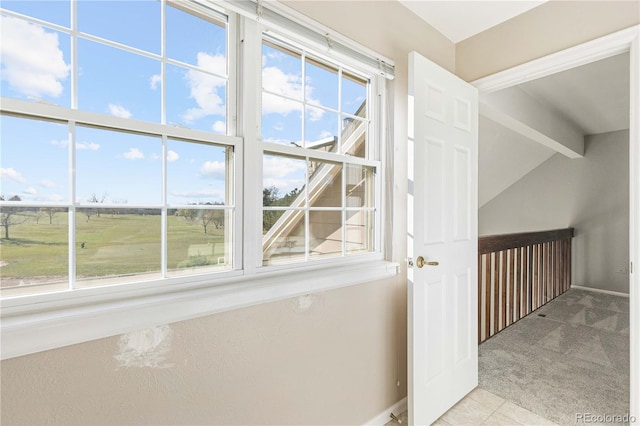 hall featuring vaulted ceiling with beams, a wealth of natural light, and light colored carpet