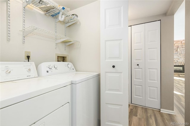 washroom with light wood-type flooring and washing machine and dryer