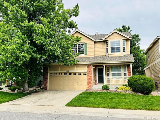 6102 S Yampa St, Aurora, CO 80016 - traditional-style home with covered porch, driveway, a garage, brick siding, and a front yard