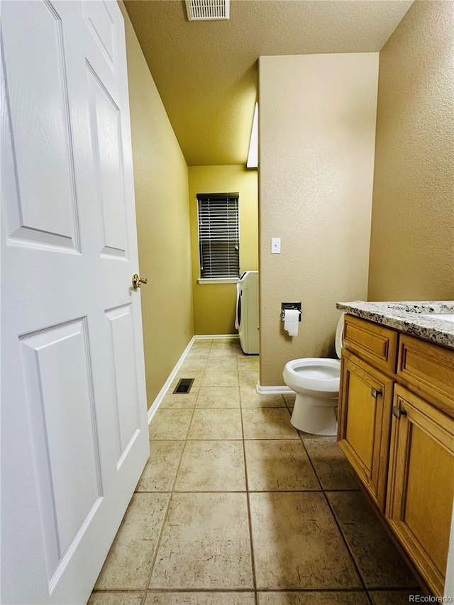 6102 S Yampa St, Aurora, CO 80016 - bathroom featuring washer / clothes dryer, vanity, a textured ceiling, and tile patterned flooring