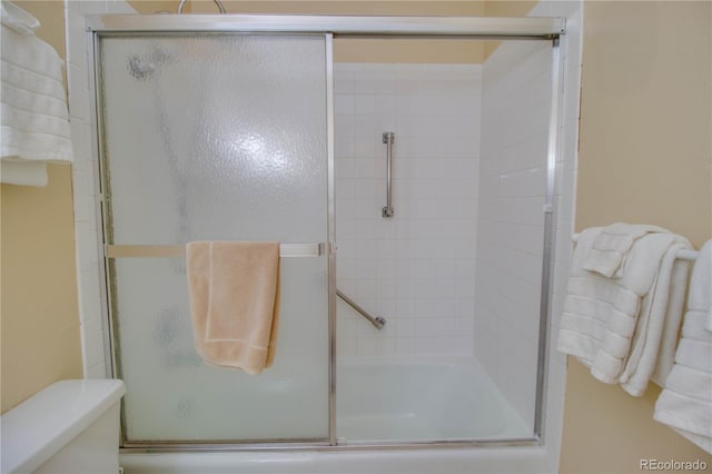 full bathroom featuring enclosed tub / shower combo and toilet