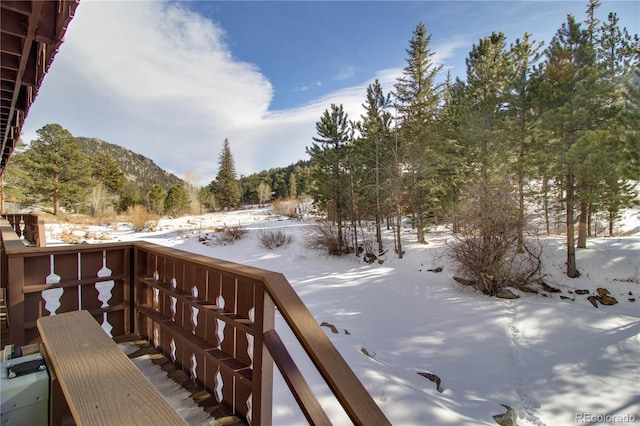 snow covered deck featuring a mountain view