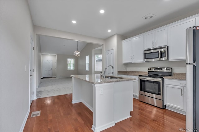 3678 Shadow Cir, Castle Rock, CO 80109 - kitchen with appliances with stainless steel finishes, white cabinets, wood finished floors, recessed lighting, and vaulted ceiling