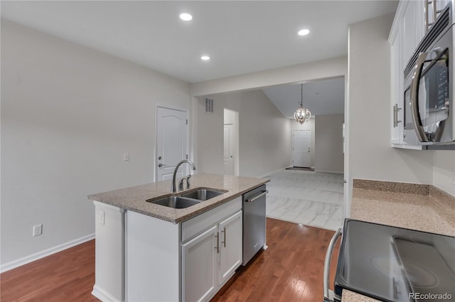 3678 Shadow Cir, Castle Rock, CO 80109 - kitchen featuring stainless steel appliances, white cabinets, dark wood-style floors, recessed lighting, and light stone counters