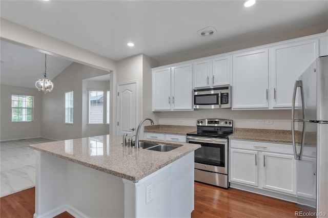 3678 Shadow Cir, Castle Rock, CO 80109 - kitchen with stainless steel appliances, white cabinets, vaulted ceiling, light stone counters, and recessed lighting