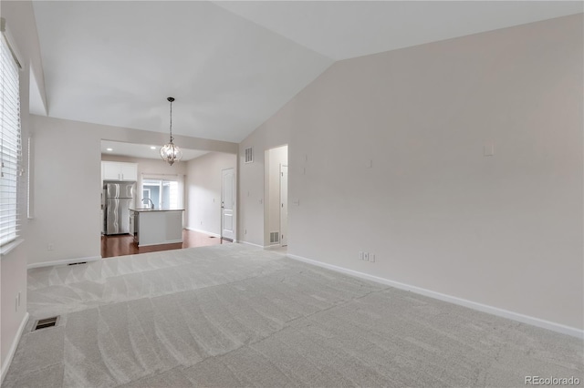 3678 Shadow Cir, Castle Rock, CO 80109 - unfurnished living room featuring lofted ceiling, carpet flooring, and a chandelier