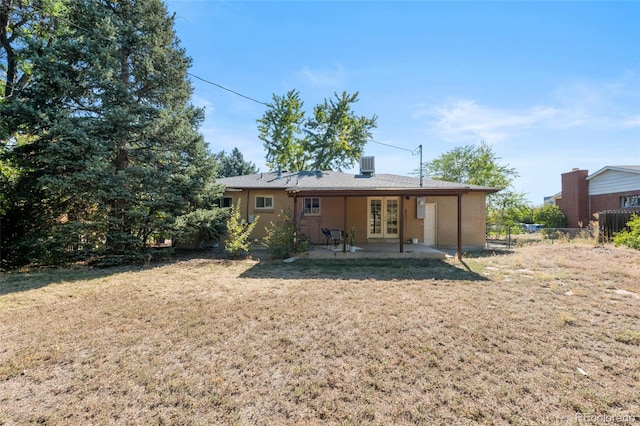 rear view of house with a yard, a patio, and central AC unit