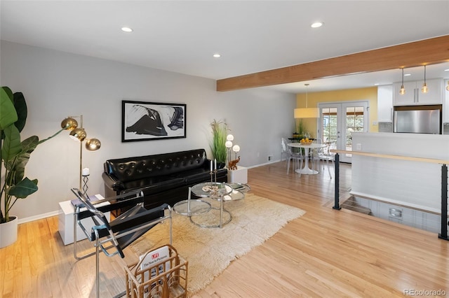 living room featuring beamed ceiling, french doors, and light wood-type flooring