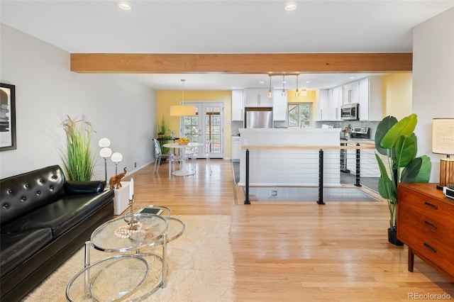 living room with french doors, beamed ceiling, and light wood-type flooring