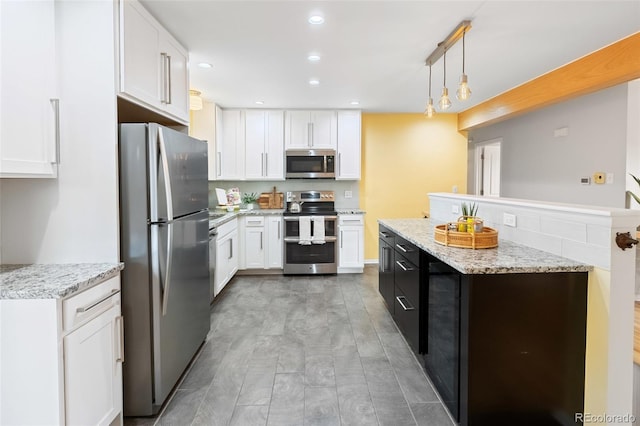 kitchen featuring pendant lighting, light stone countertops, appliances with stainless steel finishes, light hardwood / wood-style floors, and white cabinetry