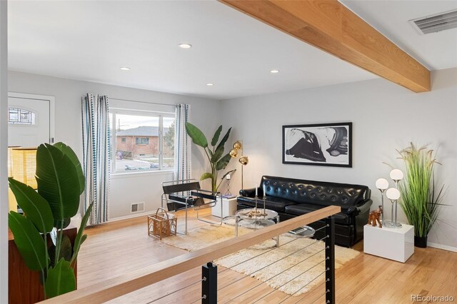 living room with beam ceiling and light hardwood / wood-style floors