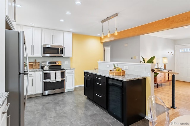 kitchen featuring pendant lighting, white cabinetry, stainless steel appliances, and wine cooler