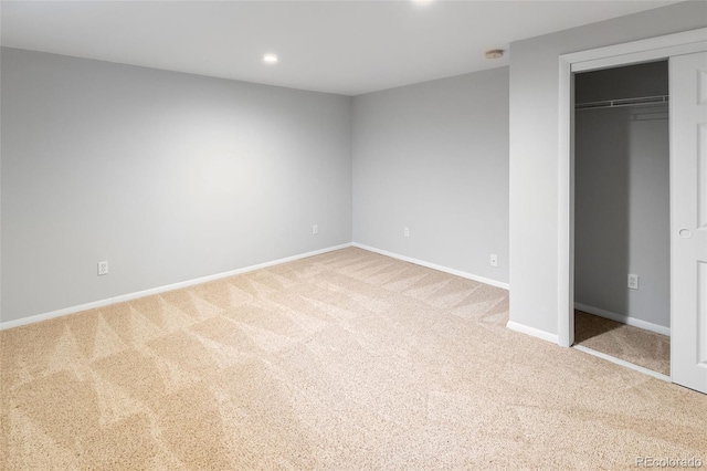 unfurnished bedroom featuring light colored carpet and a closet