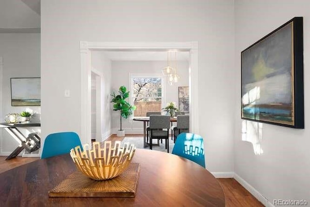 dining area featuring hardwood / wood-style floors and a chandelier