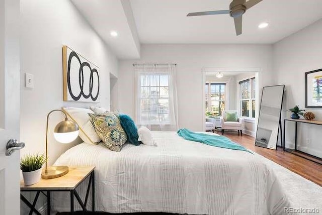 bedroom with multiple windows, ceiling fan, and wood-type flooring