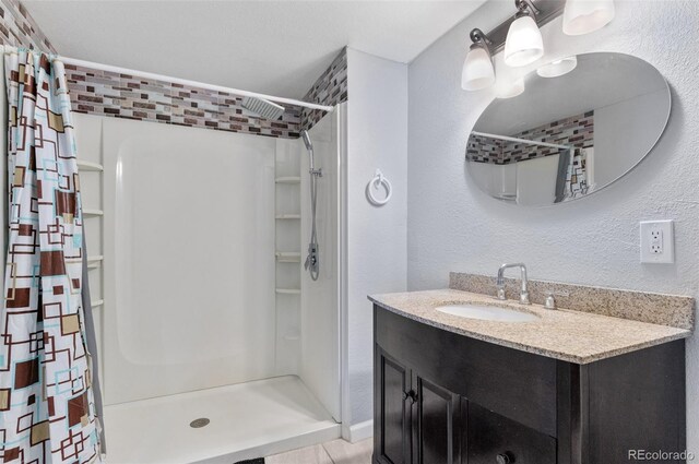 23593 E Chenango Pl, Aurora, CO 80016 - bathroom with a shower with shower curtain, vanity, and a textured wall