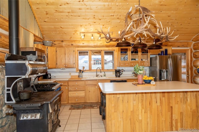 kitchen featuring stainless steel fridge, a sink, lofted ceiling, wood ceiling, and light countertops