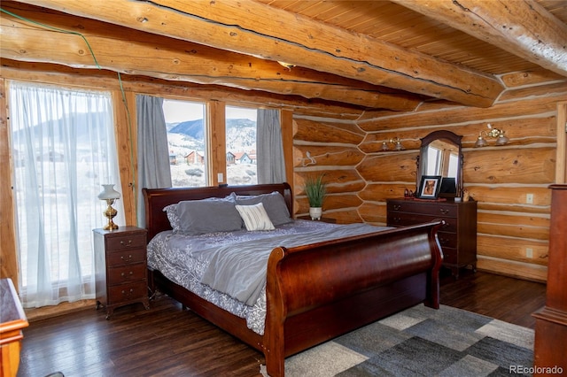 bedroom featuring dark wood-style floors, rustic walls, beamed ceiling, and a mountain view