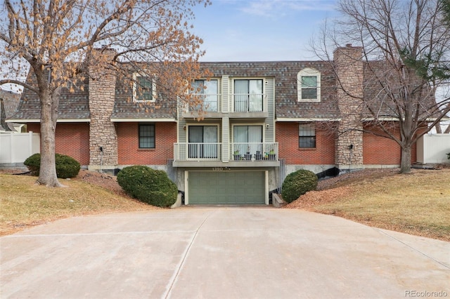 townhome / multi-family property featuring a garage, a front lawn, and a balcony